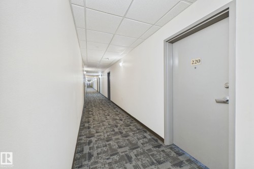Hallway featuring patterned carpeting, white walls, recessed lighting, and a drop ceiling - 220 80A Kelloway Crescent, Red Deer, AB - Indoor Photo Showing Other Room