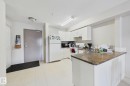 Kitchen featuring white cabinetry, a light-toned countertop, and tile flooring - 220 80A Kelloway Crescent, Red Deer, AB  - Indoor Photo Showing Kitchen 