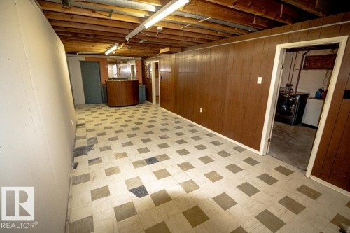 Spacious lower-level area featuring exposed wooden ceiling beams and fluorescent lighting - 4822 45 Ave, St. Paul Town, AB - Indoor Photo Showing Basement