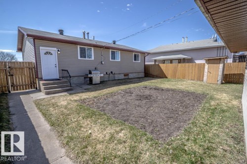 Rear exterior featuring horizontal siding, a fenced yard, and an exterior door with concrete steps - 4822 45 Ave, St. Paul Town, AB - Outdoor With Exterior