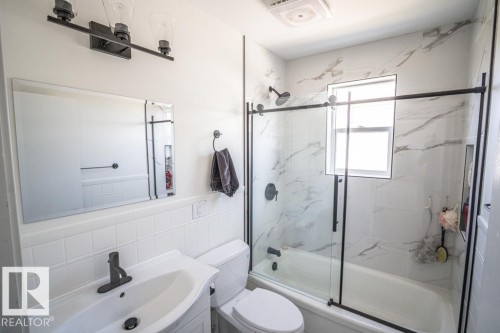 Bathroom featuring a white vanity with integrated sink, matte black faucet, and a large wall mirror - 4822 45 Ave, St. Paul Town, AB - Indoor Photo Showing Bathroom