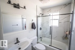 Bathroom featuring a white vanity with integrated sink, matte black faucet, and a large wall mirror - 