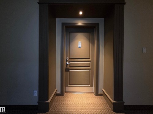 Entryway featuring a paneled door with brushed nickel hardware, recessed lighting, and patterned carpet flooring - 109 160 Magrath Rd, Edmonton, AB - Indoor Photo Showing Other Room