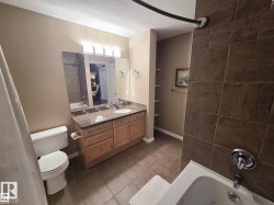 Bathroom featuring a vanity with a granite countertop, undermount sink, and wood cabinetry - 
