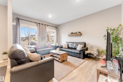 Spacious living area featuring light wood-finish flooring and neutral wall tones - 
