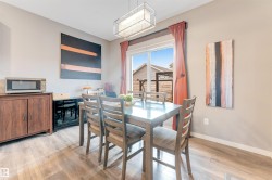 Dining space featuring wood-finish flooring, a sliding glass door, and a rectangular ceiling light fixture - 