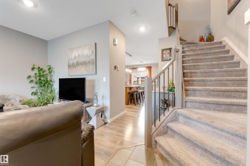 Carpeted staircase with contemporary railing featuring metal balusters and a wood-finish handrail - 2652 Maple Way, Edmonton, AB - Indoor Photo Showing Other Room