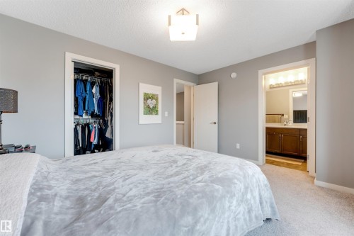 Carpeted room featuring a built-in closet with shelving and hanging rods - 2652 Maple Way, Edmonton, AB - Indoor Photo Showing Bedroom