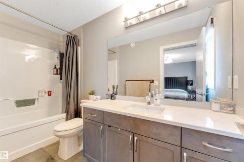 Bathroom featuring a large vanity with a light countertop, a single undermount sink, and a chrome faucet - 2652 Maple Way, Edmonton, AB - Indoor Photo Showing Bathroom