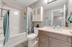 Full bathroom featuring a single vanity with integrated sink, stone countertop, and wood-finish cabinetry - 