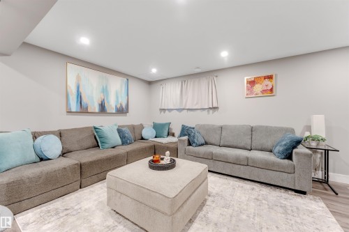 Spacious living area featuring light gray walls, recessed lighting, and wood-finish flooring - 2652 Maple Way, Edmonton, AB - Indoor