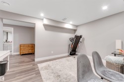 Spacious room with recessed lighting and contemporary wood-finish flooring - 