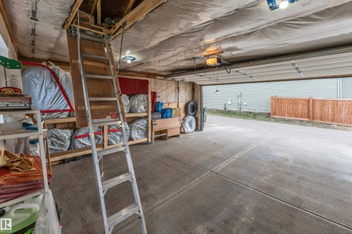 Attached garage with exposed wood beam ceiling, concrete flooring, and an overhead door - 2652 Maple Way, Edmonton, AB - Indoor Photo Showing Garage