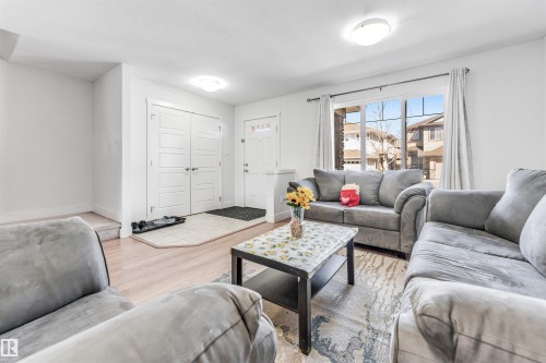 Living area featuring wood-finish flooring, a large window with white trim, and recessed lighting - 1536 21 Street, Edmonton, AB - Indoor Photo Showing Living Room