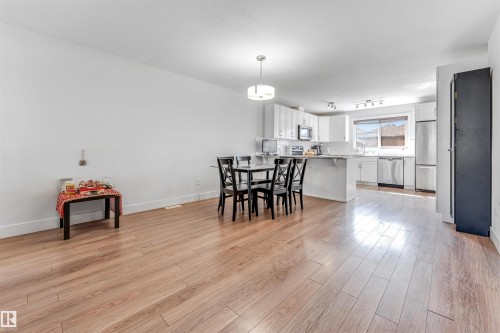 Open-concept living area featuring wood-finish flooring, white walls, and a modern kitchen - 1536 21 Street, Edmonton, AB - Indoor Photo Showing Dining Room