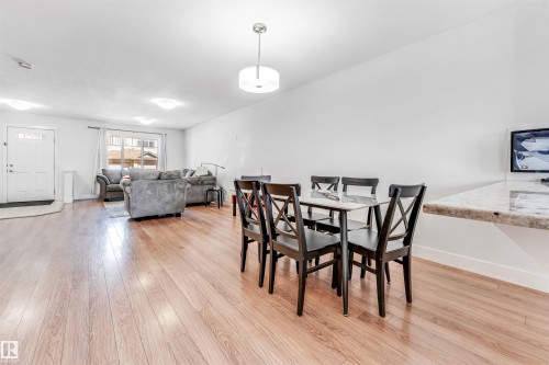Open-concept living space featuring wood-finish flooring, recessed lighting, and a front entry door with decorative glass inserts - 1536 21 Street, Edmonton, AB - Indoor