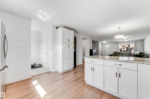 Kitchen featuring wood-finish flooring, white cabinetry with silver hardware, and a light-toned countertop - 1536 21 Street, Edmonton, AB - Indoor Photo Showing Kitchen