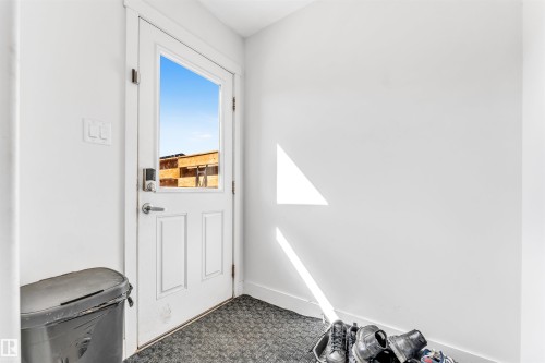 Entryway featuring a paneled door with a glass insert, smart lock hardware, a brushed nickel handle, and a textured floor covering - 1536 21 Street, Edmonton, AB - Indoor Photo Showing Other Room