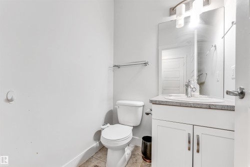 Bathroom featuring a white vanity with slab cabinet doors, a drop-in sink, and a contrasting countertop - 1536 21 Street, Edmonton, AB - Indoor Photo Showing Bathroom
