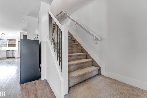 Carpeted staircase with wrought iron balusters and a painted handrail - 1536 21 Street, Edmonton, AB - Indoor Photo Showing Other Room
