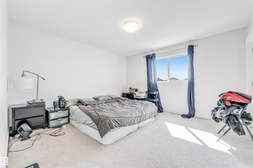 Bright room featuring a window with a distant landscape, neutral wall color, and light-colored carpeting - 1536 21 Street, Edmonton, AB - Indoor Photo Showing Bedroom