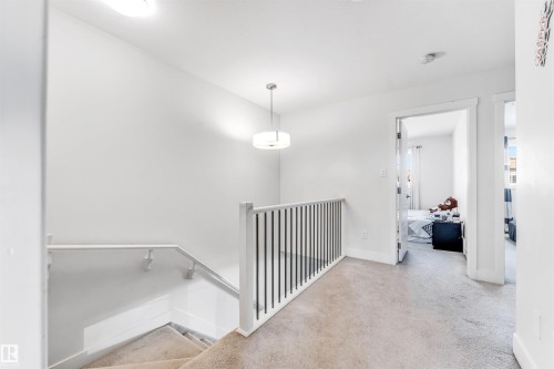 Upper-level landing featuring carpeted flooring and a modern pendant light fixture - 1536 21 Street, Edmonton, AB - Indoor Photo Showing Other Room