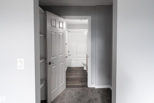 Bathroom featuring a white tub, toilet, and wood-finish flooring - 4407 23 Street, Edmonton, AB - Indoor Photo Showing Other Room