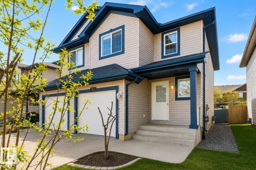 Two-story residence featuring light-toned siding with dark trim accents - 704 83 Street, Edmonton, AB - Outdoor