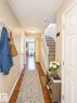 Entryway featuring wood-finish flooring, a carpeted staircase with white railing, and flush-mount lighting - 704 83 Street, Edmonton, AB  - Indoor Photo Showing Other Room 