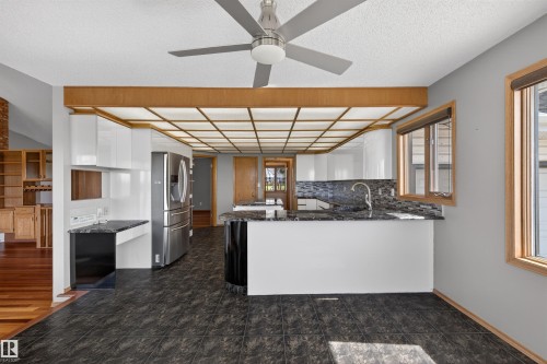 Kitchen featuring dark tile flooring, white cabinetry, dark stone countertops, and a modern ceiling fan - 19403 Fort Road, Edmonton, AB - Indoor Photo Showing Kitchen