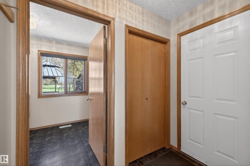 Entryway featuring a six-panel white door, a wood-finish bi-fold door, and wood-trim door frames - 19403 Fort Road, Edmonton, AB - Indoor Photo Showing Other Room