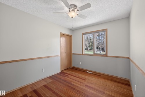 Interior space featuring wood-finish flooring, a ceiling fan with integrated lighting, and a double-pane window - 19403 Fort Road, Edmonton, AB - Indoor Photo Showing Other Room