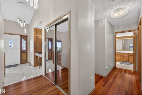 Entryway featuring a white paneled door with decorative glass inserts, a wood-finish side door, and contrasting tile and wood-finish flooring - 19403 Fort Road, Edmonton, AB - Indoor Photo Showing Other Room