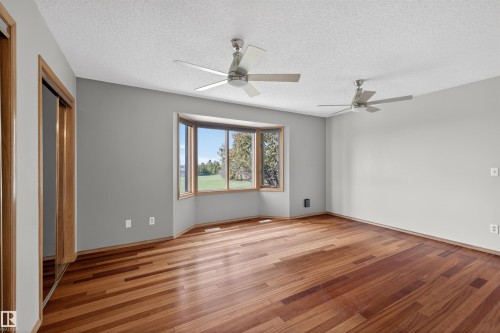 Spacious room featuring wood-finish flooring and a multi-paned bay window - 19403 Fort Road, Edmonton, AB - Indoor Photo Showing Other Room