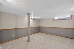 Finished room featuring textured carpet, a drop ceiling, and a structural column - 