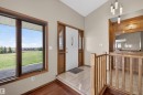 Entryway with wood-finish flooring, a white front door with decorative glass inserts, and an expansive window with dark wood framing - 19403 Fort Road, Edmonton, AB  - Indoor Photo Showing Other Room 