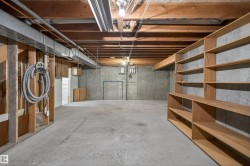 Unfinished basement with exposed ceiling joists and concrete flooring - 