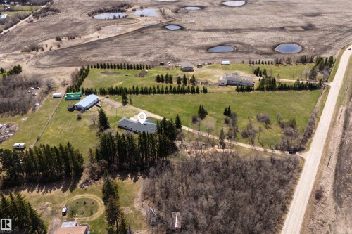 Expansive rural property featuring multiple structures including a main residence with a dark shingle roof, a large metal-clad outbuilding, and additional smaller structures - 19403 Fort Road, Edmonton, AB - Outdoor With View