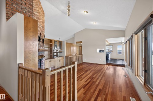 Vaulted ceilings and wood-finish flooring characterize this open living area - 19403 Fort Road, Edmonton, AB - Indoor Photo Showing Other Room