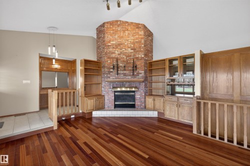Vaulted ceiling over a living space featuring wood-finish flooring - 19403 Fort Road, Edmonton, AB - Indoor With Fireplace