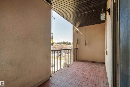 Private balcony featuring wood-finish flooring, a wrought iron railing, and stucco walls - 316 10520 56 Avenue Nw, Edmonton, AB - Outdoor With Balcony With Exterior