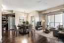 Open-concept living space featuring wood-finish flooring, a kitchen with dark cabinetry and stainless steel appliances, a dining area with a chandelier, and a living area with a sliding glass door to a balcony - 316 10520 56 Avenue Nw, Edmonton, AB  - Indoor 