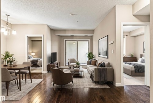 Open concept living and dining areas featuring dark wood-finish flooring, neutral wall tones, and recessed lighting - 316 10520 56 Avenue Nw, Edmonton, AB - Indoor
