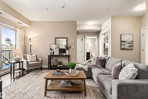 Hardwood-style flooring throughout the primary living area features a glass sliding door providing access to an outdoor balcony - 316 10520 56 Avenue Nw, Edmonton, AB - Indoor Photo Showing Living Room