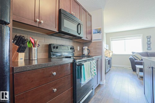 Convenient built in microwave hood fan and quartz counter tops - 1622 33A Street Nw, Edmonton, AB - Indoor Photo Showing Kitchen