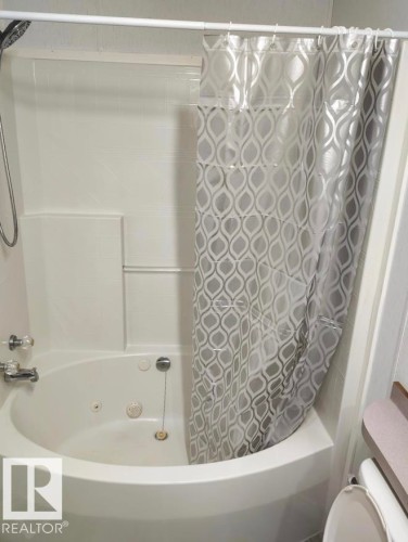 Corner soaking tub with integrated jets and a shower fixture - 109-4819 51 Ave, Millet, AB - Indoor Photo Showing Bathroom