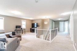 Open concept upper level featuring light gray wall tones, plush carpeting, and multiple windows - 