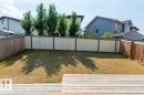Expansive backyard featuring a large grass area, wood privacy fencing, and a multi-level wood deck - 9748 205 Street, Edmonton, AB  - Outdoor 