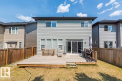 Rear exterior featuring a multi-level wood deck, privacy fencing, and sliding glass door access - 