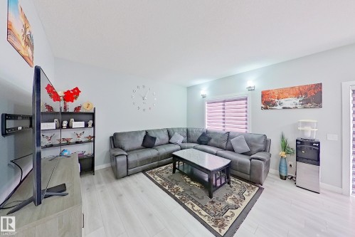 Bright living space featuring light wood-finish flooring, light gray wall tones, and recessed lighting - 1221 27 Street, Edmonton, AB - Indoor Photo Showing Living Room